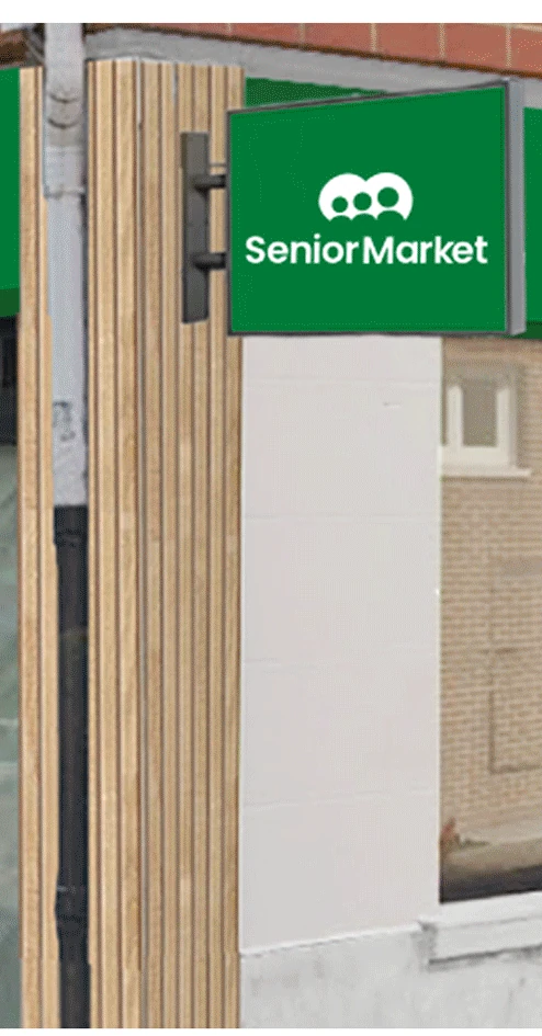 Green projecting blade sign with the Senior Market logo mounted beside a wood-clad shopfront